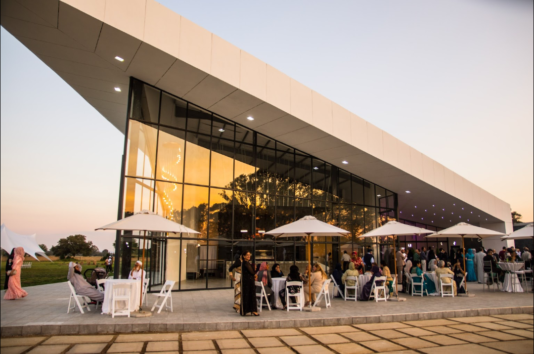 Ayana estate entrance and terrace at sunset with guests gathered outside