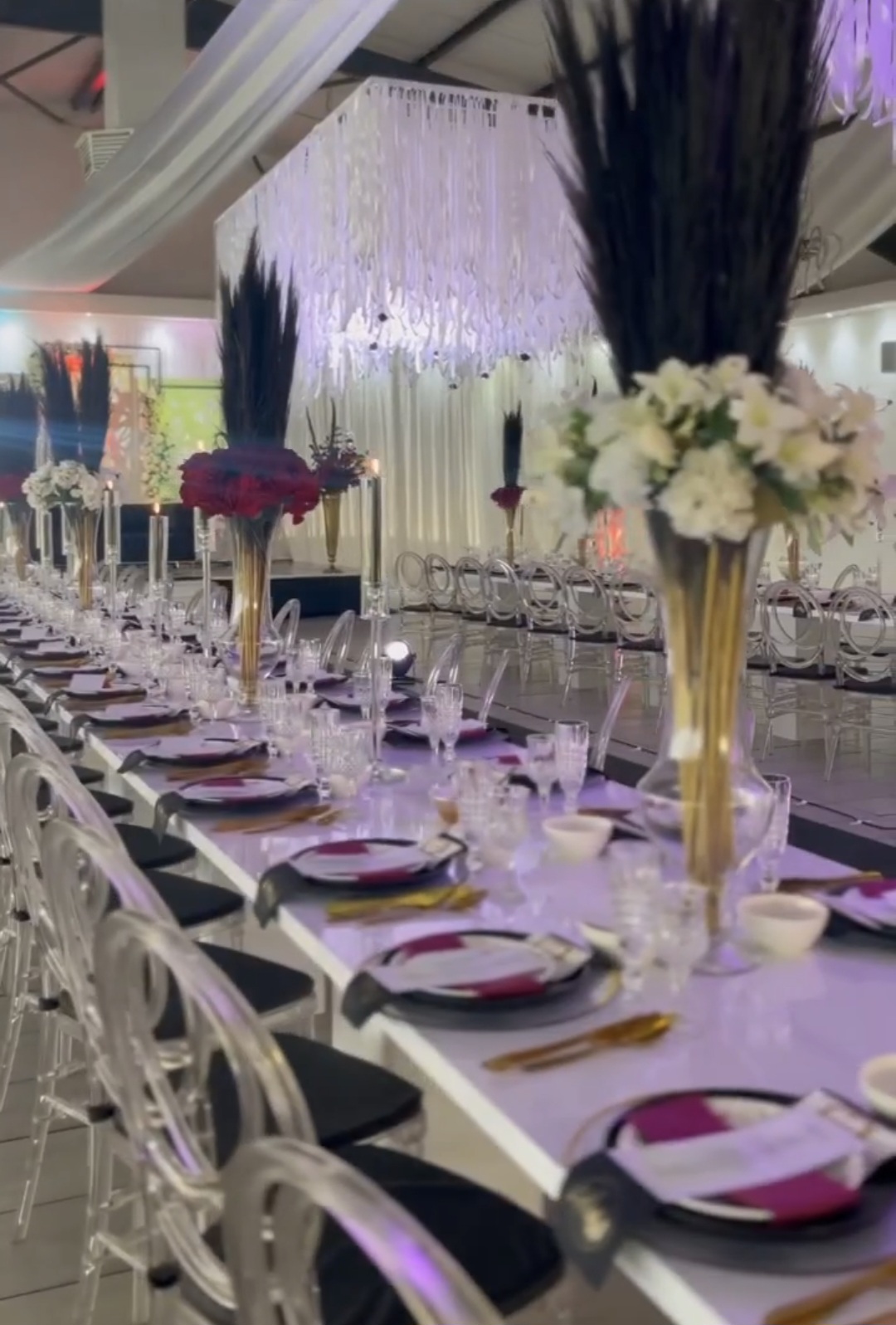 Black feather and floral centrepieces on a long table