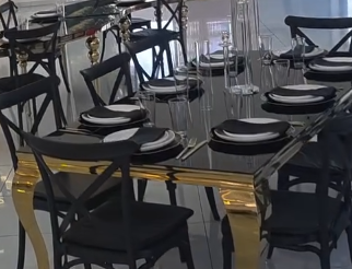 Table detail with black chairs and polished glassware