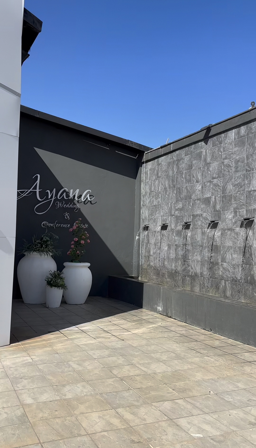 Ayana signage wall beside the tiled water feature