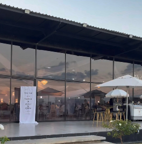 Glass hall at dusk with garden umbrellas
