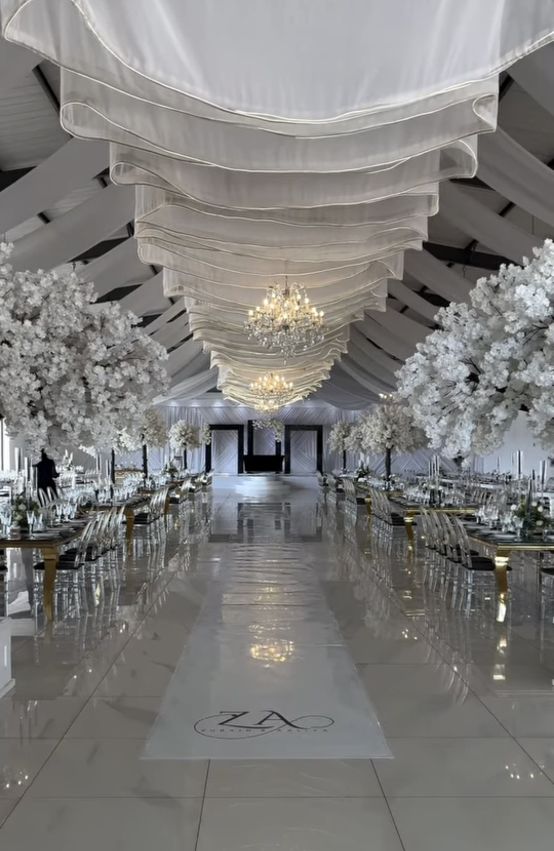 Draped hall with cherry blossom trees and mirrored aisle