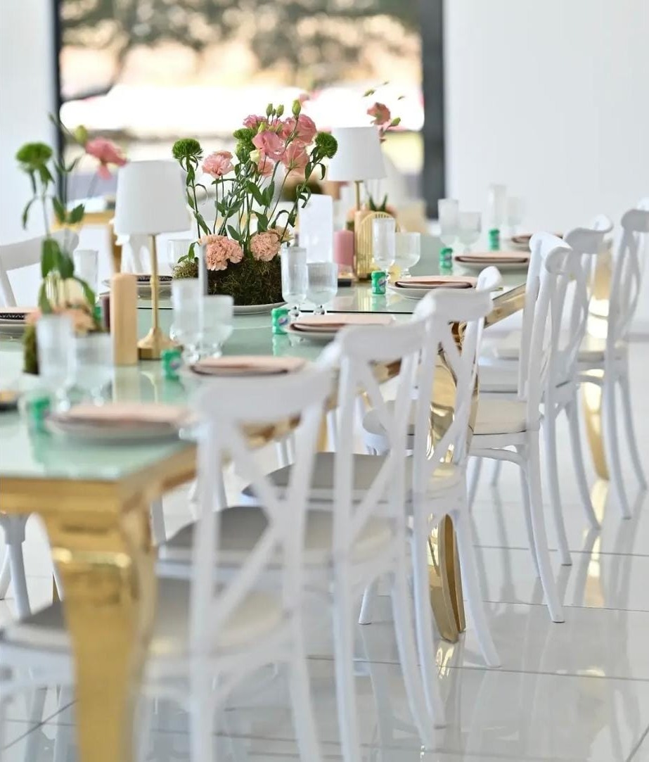 Banquet table dressed with gold frames, blush florals and mini lamps